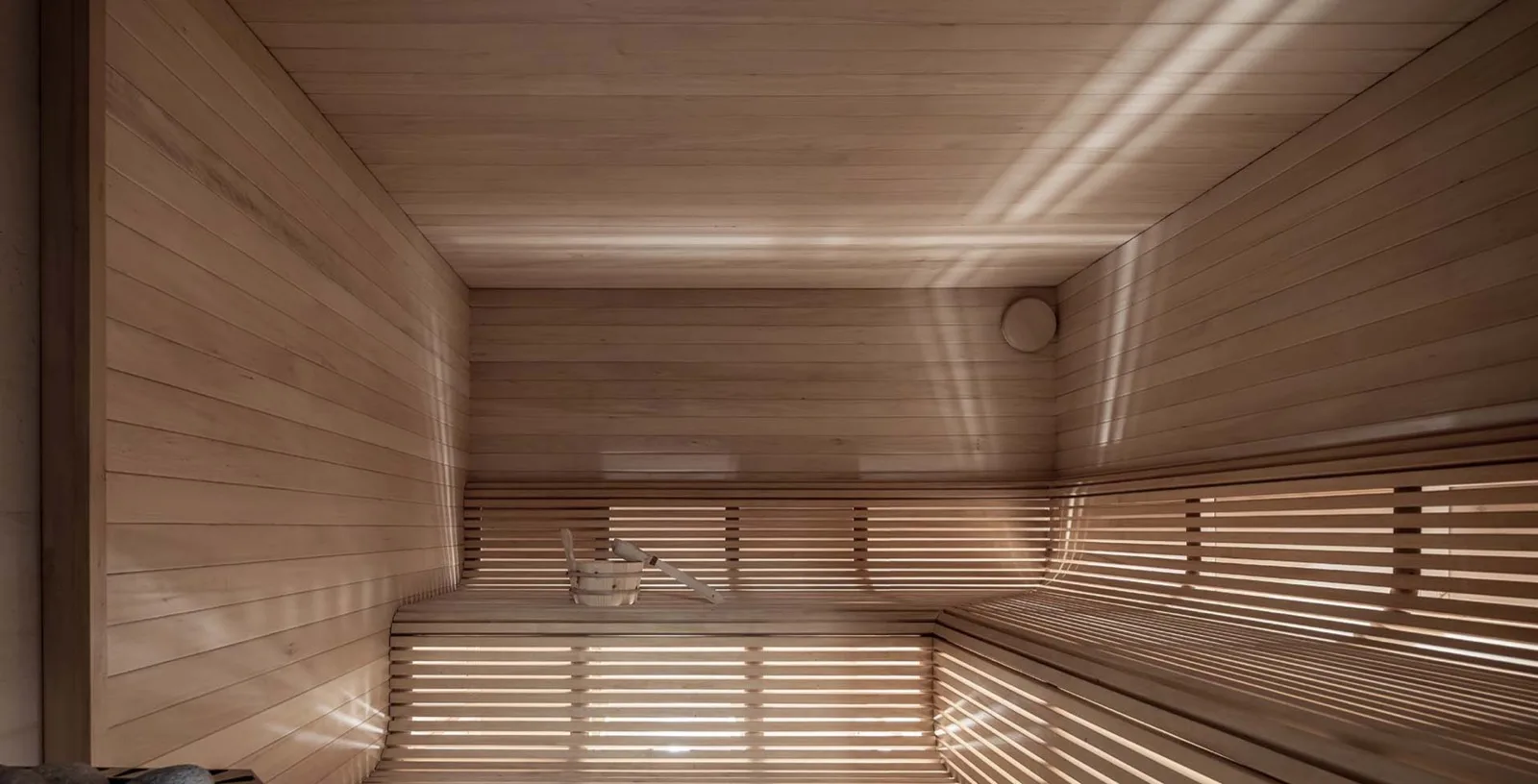 Bio sauna içi, açık renk ahşap kaplama ve yumuşak tavan ışığı