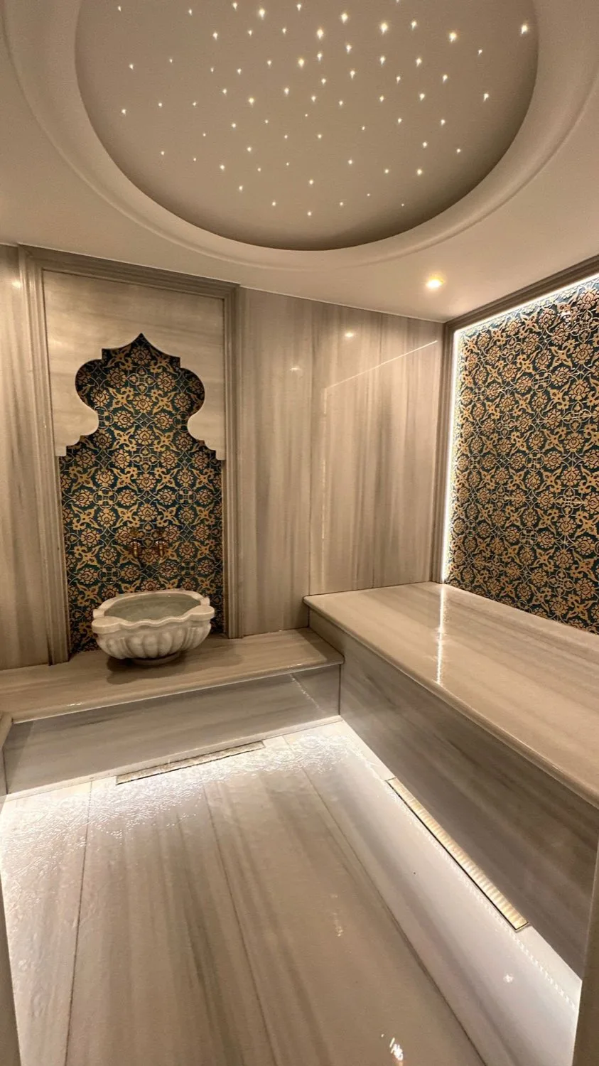Bodrum villasında hamam, çini panolu duvar ve mermer kurna