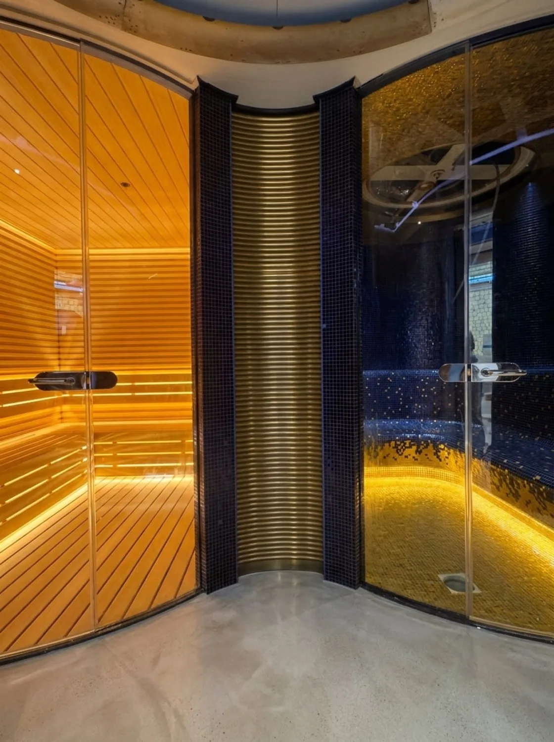 Süperyat sauna girişinde altın tonlu kolon ve cam kapı