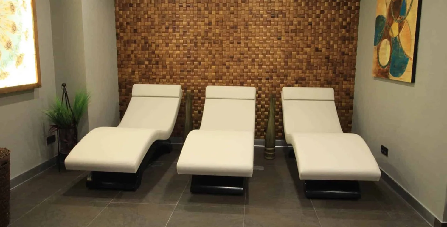 Gümüş Residence dinlenme alanı, beyaz şezlonglar ve tuğla duvar