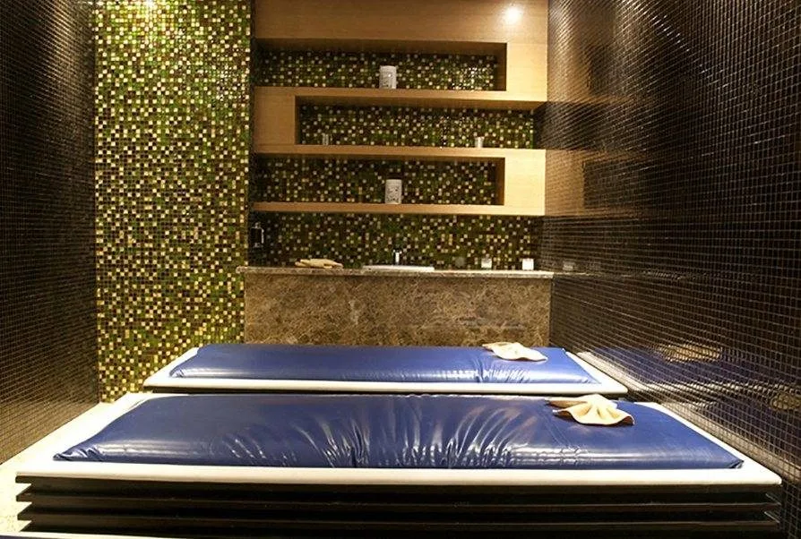 Copthorne Hotel masaj odasında iki su yatağı ve altın mozaik duvar